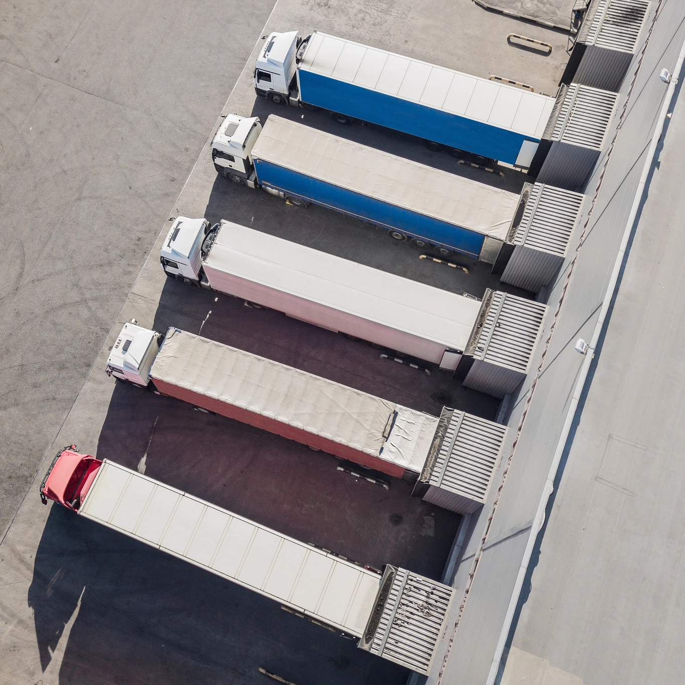 "Vue aérienne d'un centre logistique d'Innovia montrant une rangée de camions stationnés, soulignant l'efficacité et la capacité organisationnelle en matière de transport et de logistique.