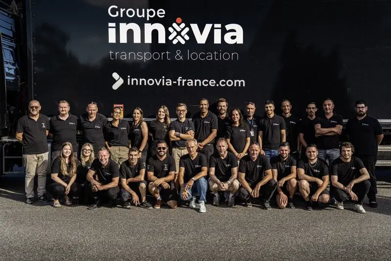 Équipe du Groupe Innovia en tenue professionnelle devant un camion de l'entreprise, illustrant la cohésion et l'expertise logistique à Toulouse.