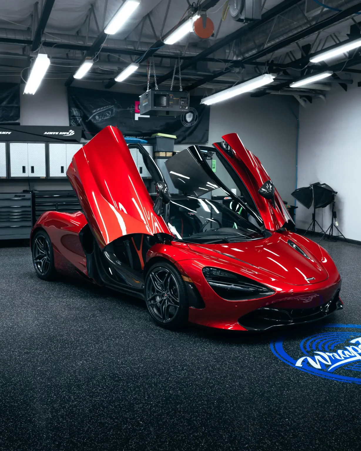 McLaren rouge brillante dans un showroom, accentuant le design élégant et l'exclusivité des voitures de luxe.